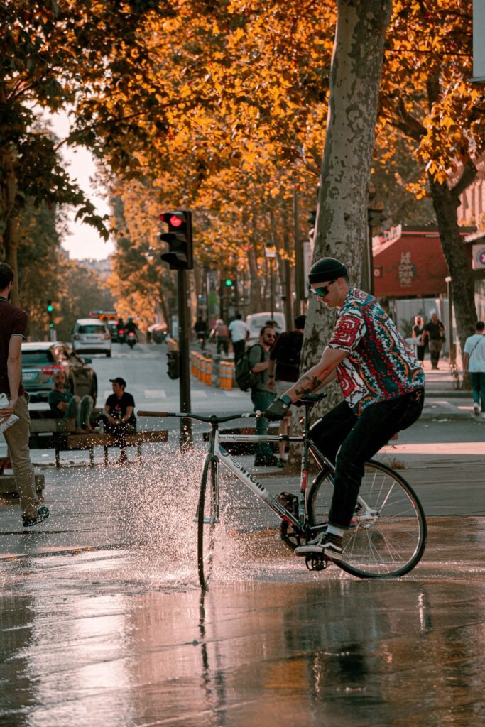 Rider et vélo reflétés parmi les jets d’eau de la place.