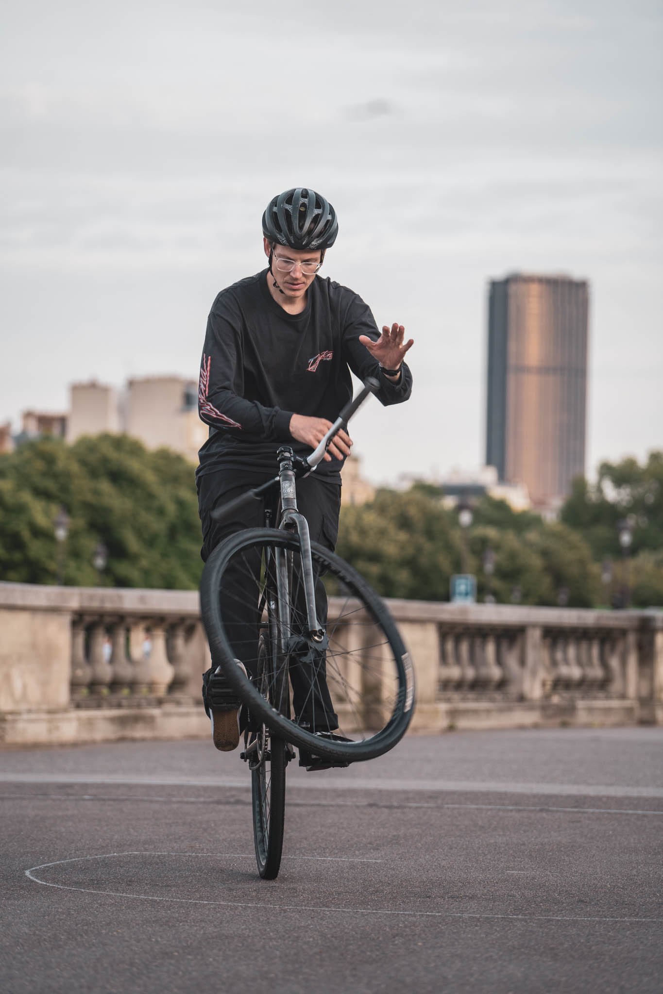 Jackson en équilibre sur la roue arrière, une main levée.