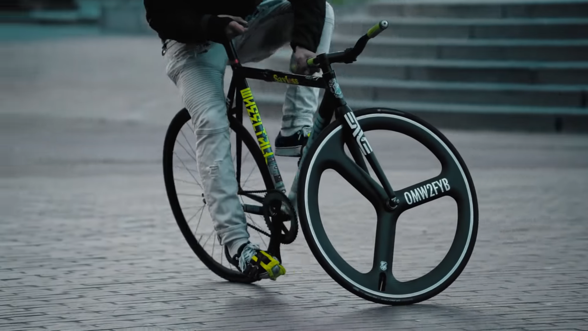 Rider exécutant un chainstay slider sur un fixie.