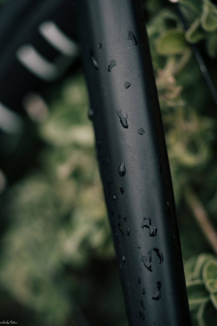 Gouttes d’eau sur une jante de vélo noire.