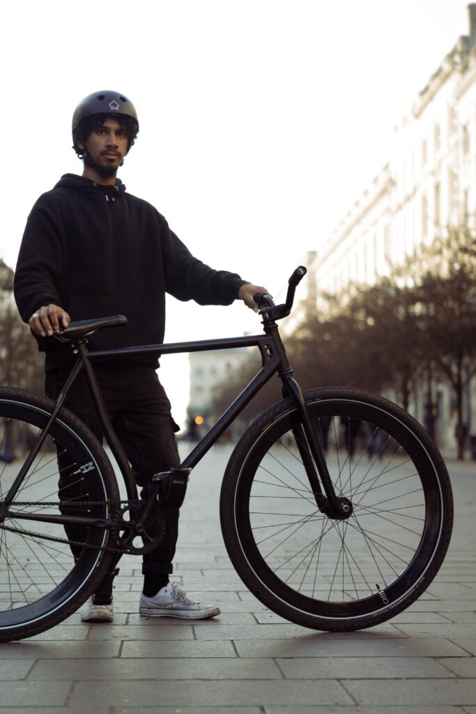 Rider casqué debout avec un pignon fixe noir.