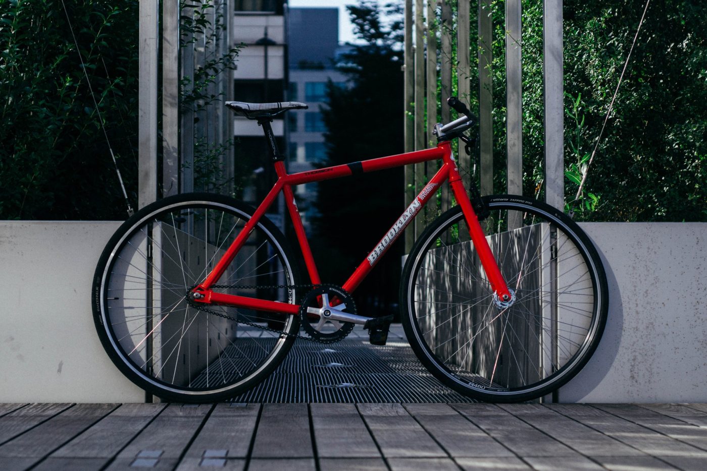 Le Brooklyn Machine Works Gangsta Track rouge de Diego sur une terrasse en bois.