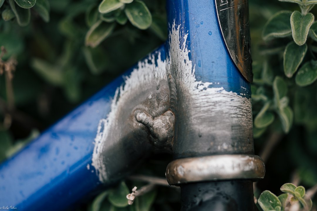 Gros plan sur la soudure et la peinture poncée autour de la douille du cadre bleu.