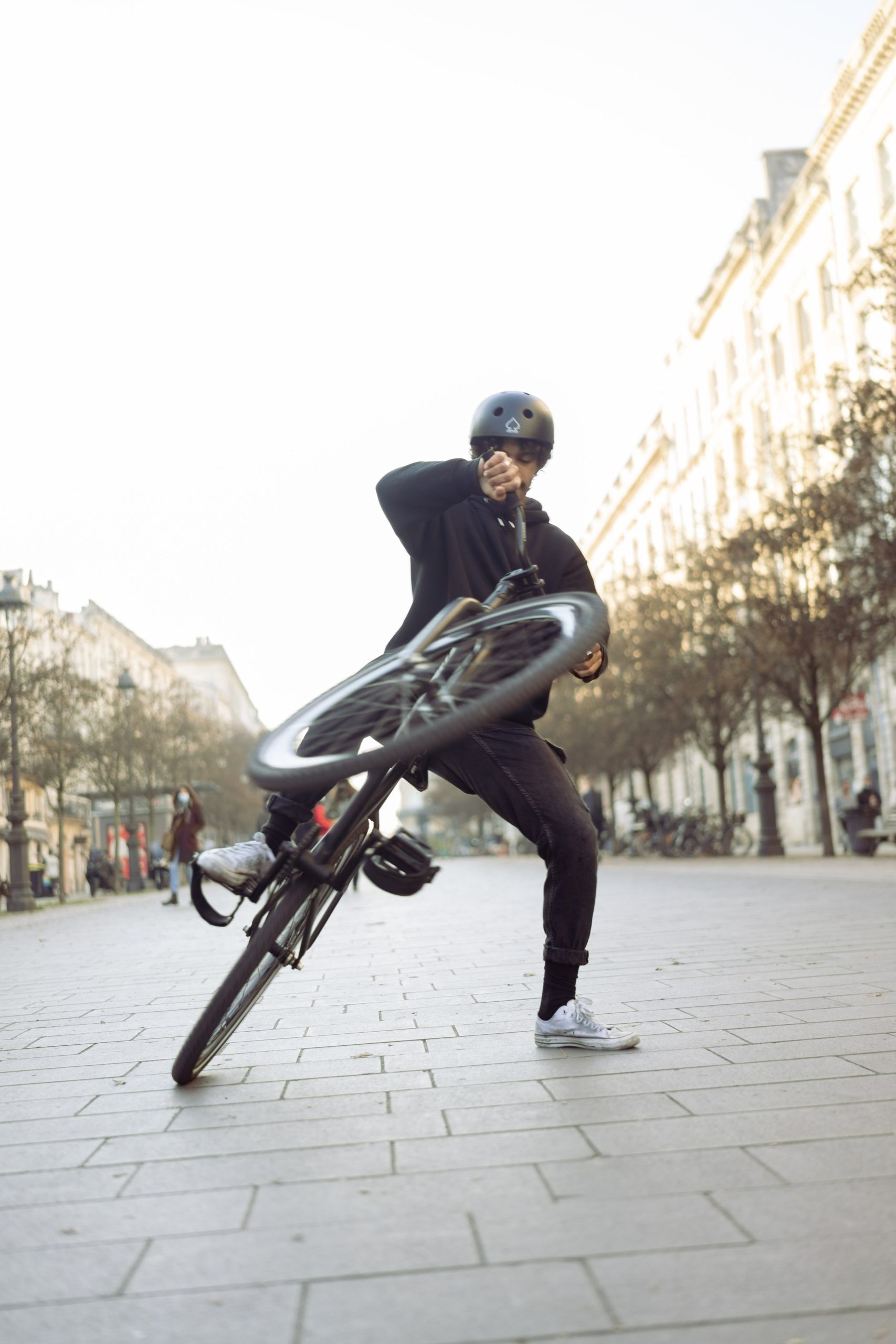 Rider inclinant un vélo noir sur le côté, un pied au sol.