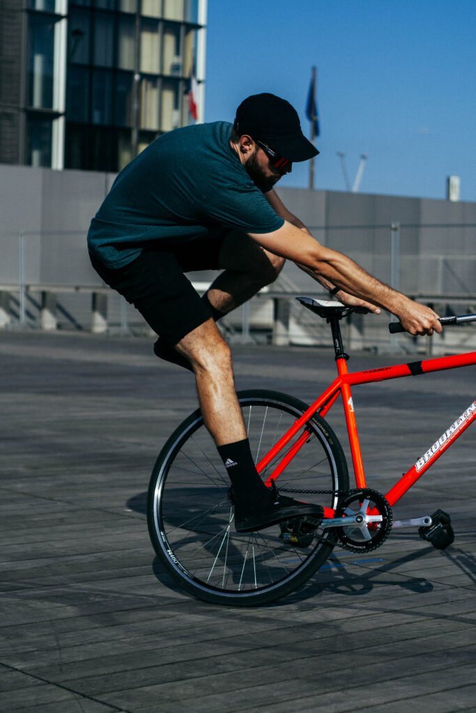 Rider faisant pivoter un vélo rouge en tenant la selle et le cintre.