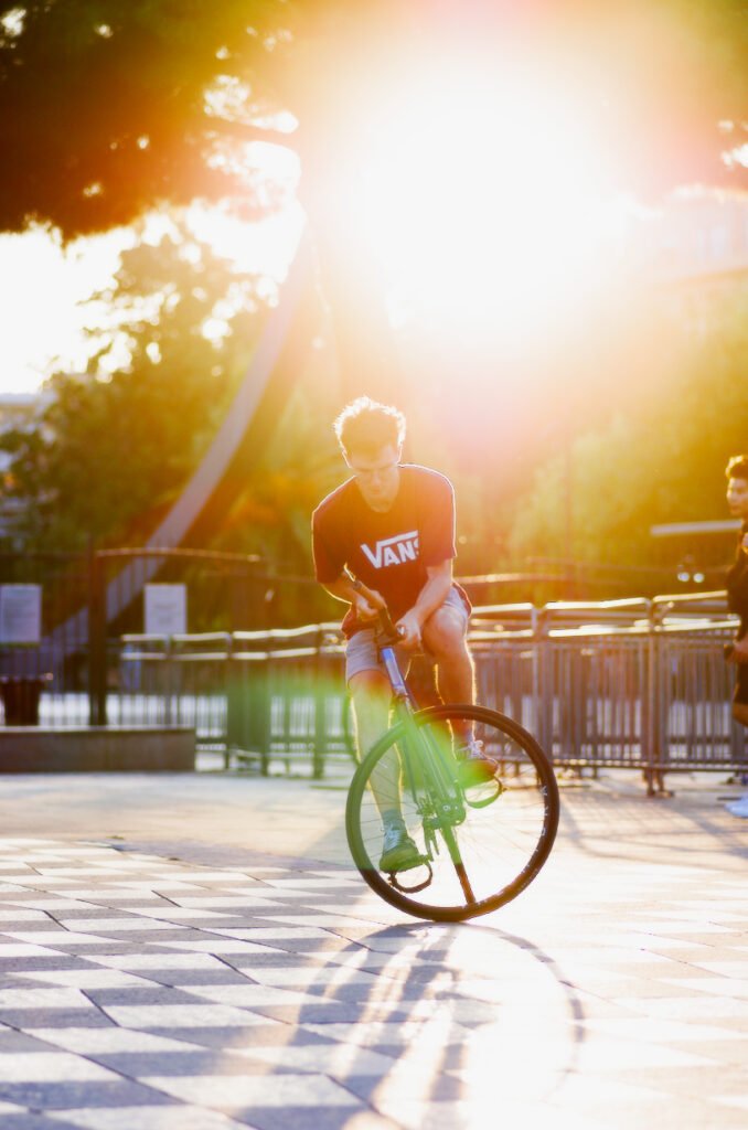 Rider faisant pivoter un vélo sur un sol à motifs dans le soleil bas.
