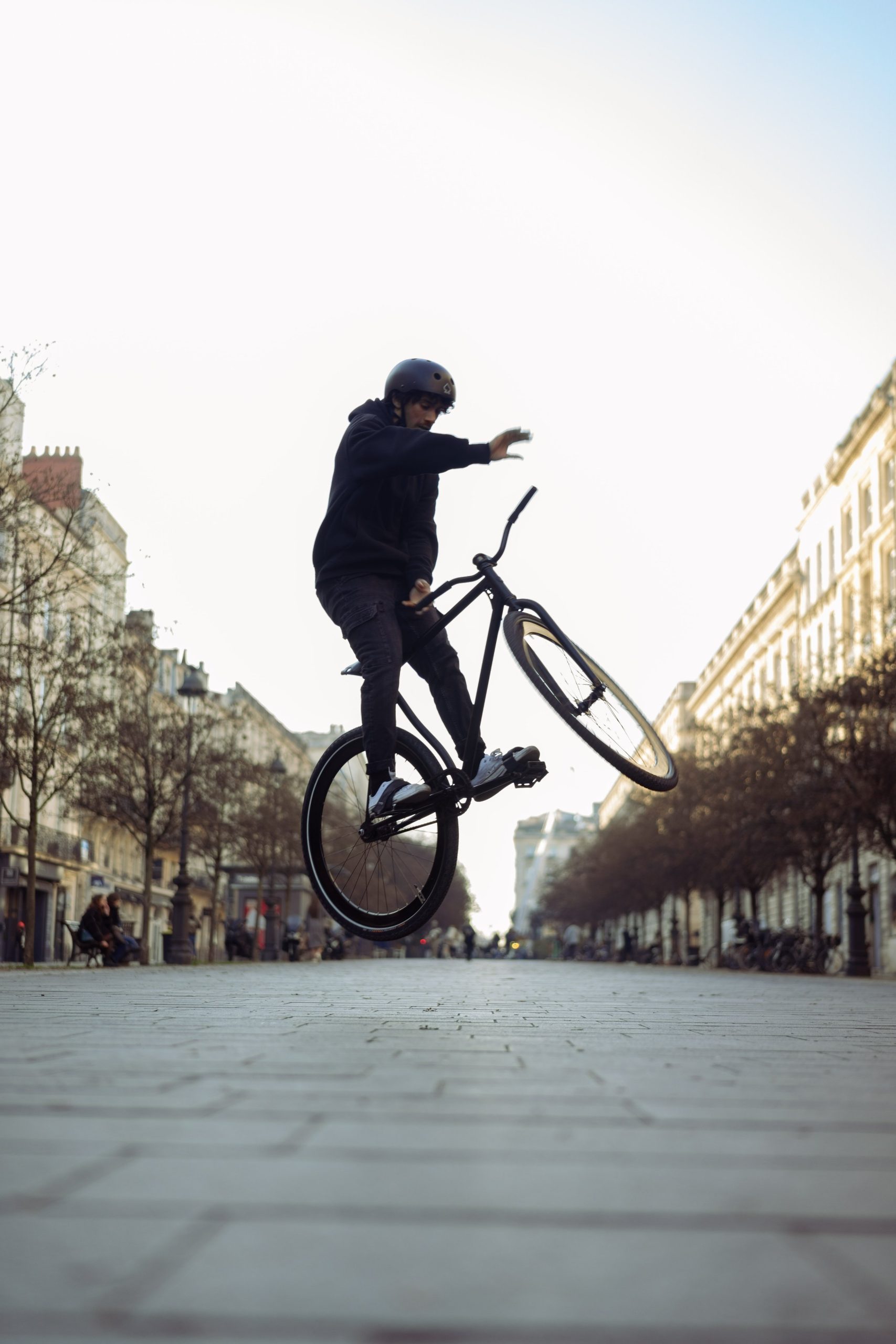 Silhouette d’un rider et de son vélo pendant un saut sur la place.