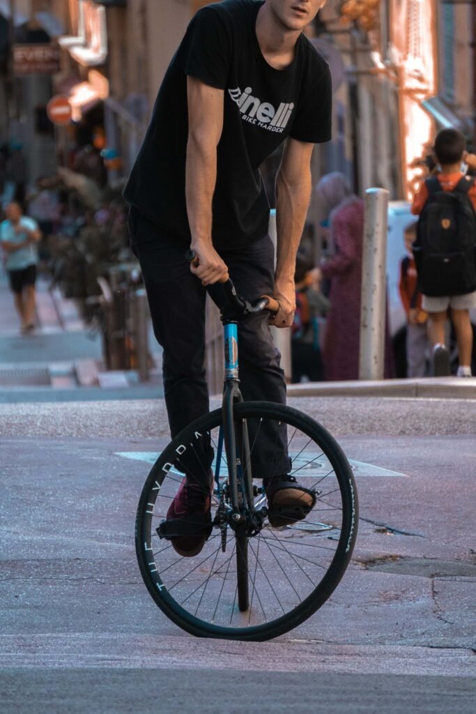 Rider penché sur un vélo noir dans une rue commerçante animée.