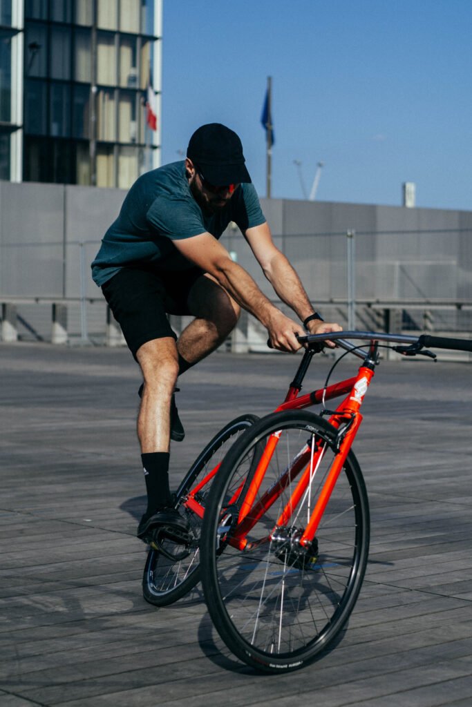 Rider penché dans un virage, la roue avant du vélo rouge tournée en travers du cadre.