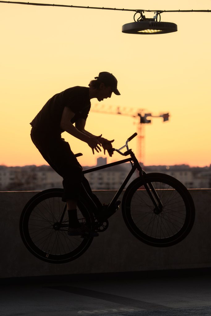 Rider en équilibre sur son fixie au coucher du soleil.