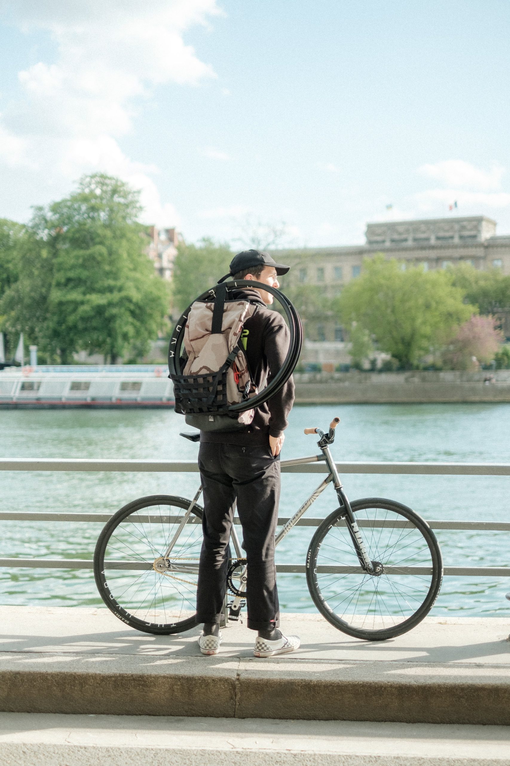 Rider debout avec un pignon fixe au bord de la Seine.